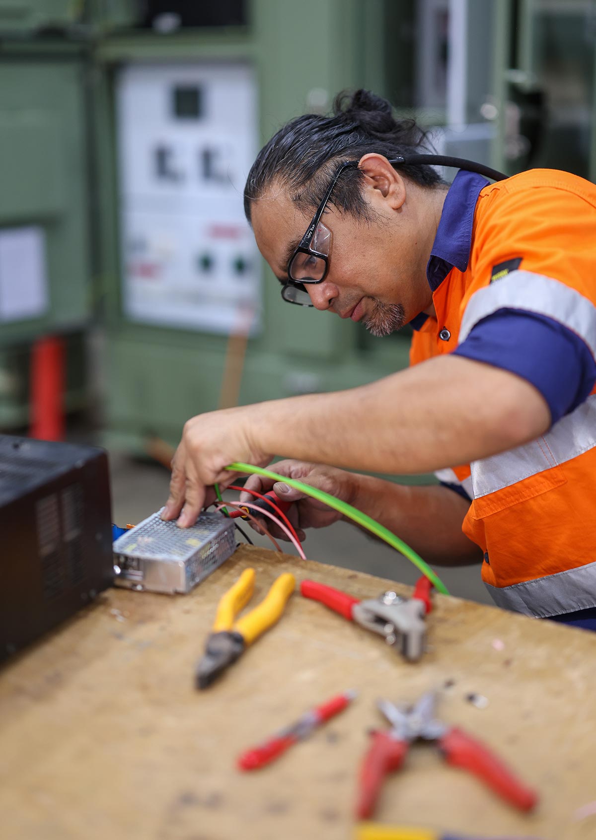 CE Group Electrical Contractor. Man working on switchboard gear