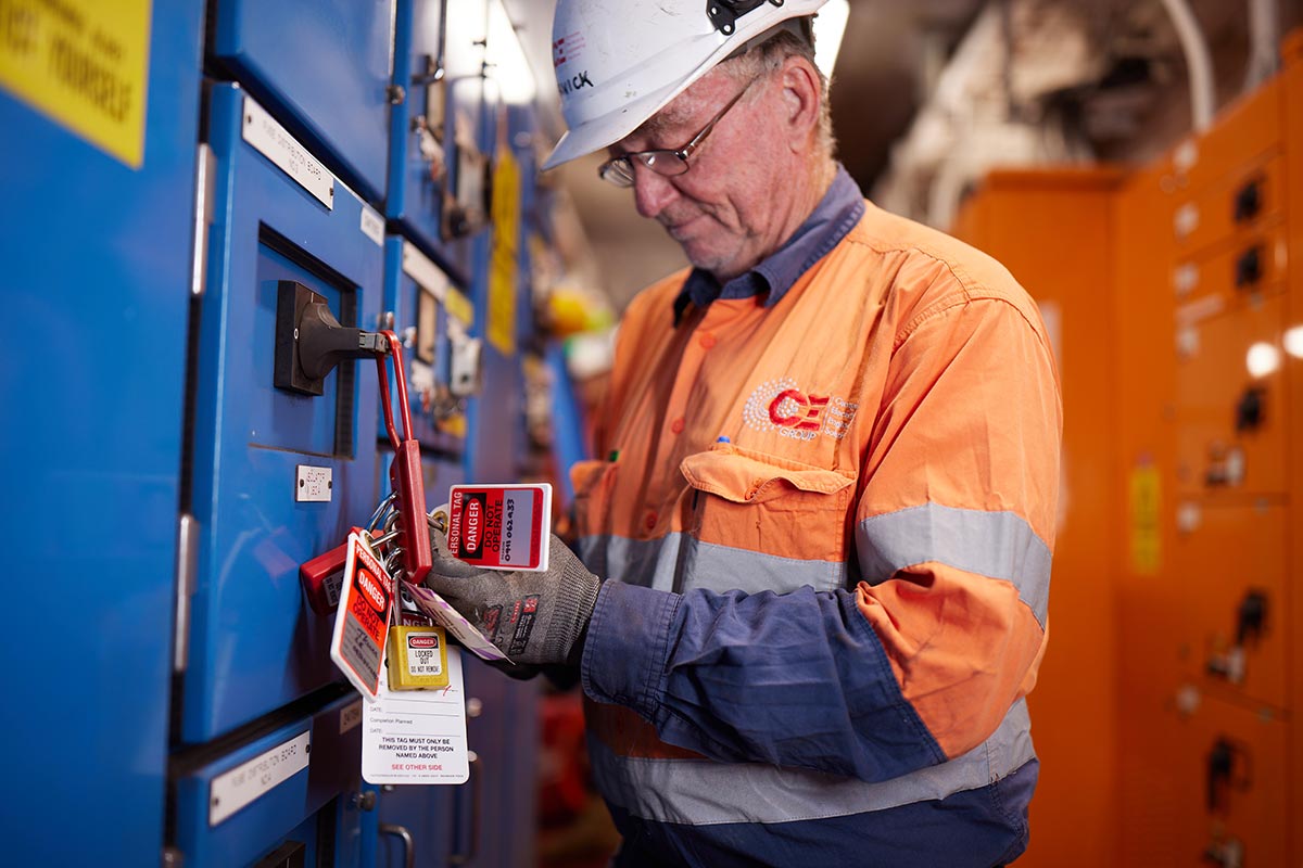 CE Group Sustainable electrical contractor. Man at switchboard with tags.